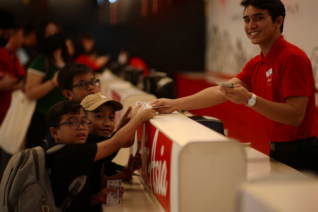 Kids purchasing tickets at a service counter in Kuala Lumpur, Malaysia.